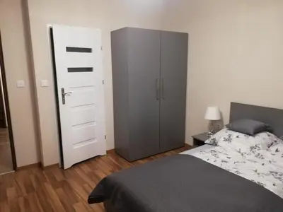 a bedroom with a bed and a tall cabinet at Olszynowy Gaj 4 in Liszki