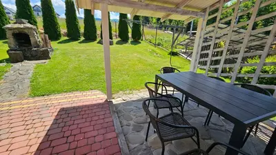 a table and chairs on a patio with an umbrella at Mały domek in Lubomierz