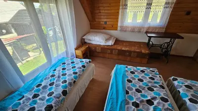 a room with two beds and a table in a cabin at Mały domek in Lubomierz