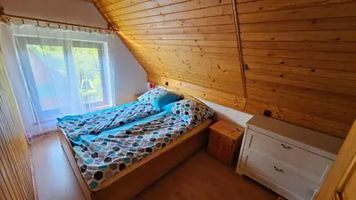 a small bed in a tiny house with a window at Mały domek in Lubomierz