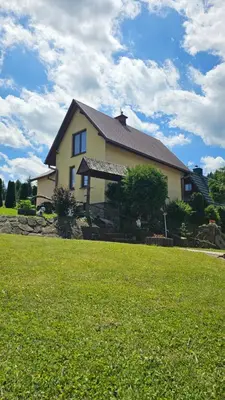 a house with a grassy field in front of a house at Mały domek in Lubomierz