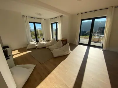 a living room with white furniture and large windows at Słoneczna przystań pod Luboniem in Rabka