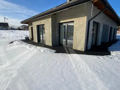 a building with snow on the ground in front of it at Słoneczna przystań pod Luboniem in Rabka
