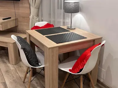 a wooden table with two chairs and a lamp at Old Town Apartments - B5 in Kraków