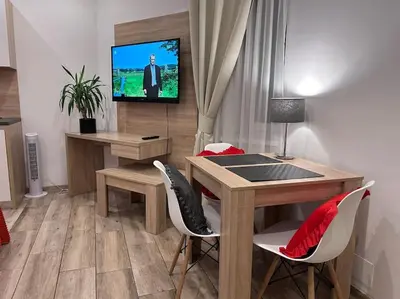 a living room with a table and a tv on a wall at Old Town Apartments - B5 in Kraków