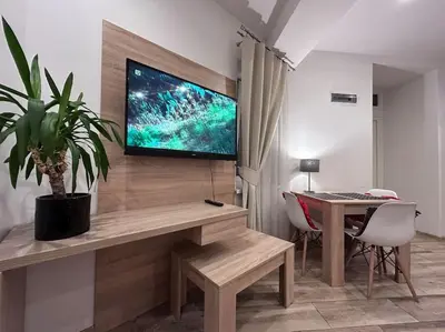 a room with a desk with a television on a wall at Old Town Apartments - B5 in Kraków