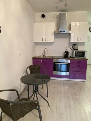 a kitchen with a purple cabinet and a table and chairs at Studio in Krakow in Kraków