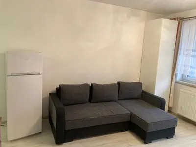 a couch in a living room with a refrigerator at Studio in Krakow in Kraków