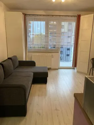 a living room with a couch and a large window at Studio in Krakow in Kraków