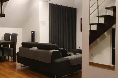 a living room with a couch and a staircase at Apartament z sauną i jacuzzi in Kraków