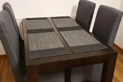 a wooden table with four chairs around it at Apartament z sauną i jacuzzi in Kraków