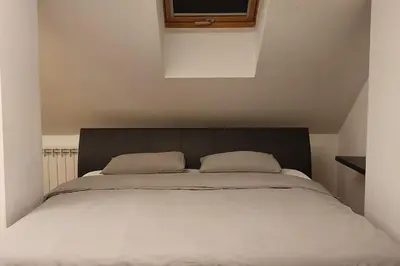 a large bed with two pillows on top of it at Apartament z sauną i jacuzzi in Kraków