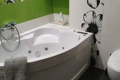 a white bath tub in a bathroom with a toilet at Apartament z sauną i jacuzzi in Kraków