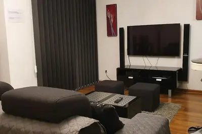 a living room with a couch and a flat screen tv at Apartament z sauną i jacuzzi in Kraków