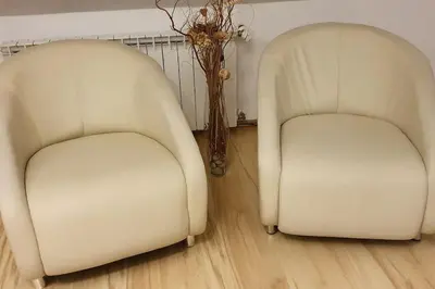 two white chairs sitting next to each other in a room at Apartament z sauną i jacuzzi in Kraków