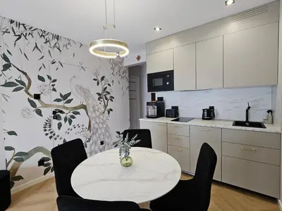 a kitchen with a table and chairs in a room at Bagry Luxury Apartment 19 in Kraków