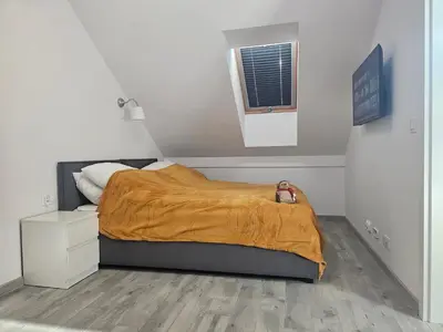 a small bedroom with a bed with a yellow blanket at Apart Bogi in Szczyglice