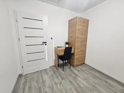 a room with a desk and a door and a chair at Apart Bogi in Szczyglice