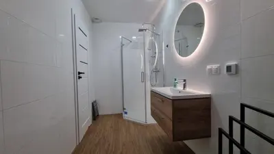 a white bathroom with a sink and a mirror at Apart Bogi in Szczyglice