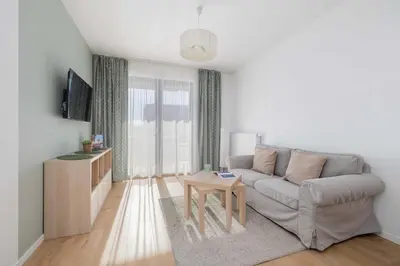a living room with a couch and a table at Modern Apartment with Parking near Tauron Arena Kraków by Noclegi Renters in Kraków