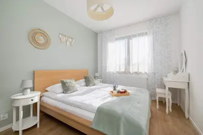 a white bedroom with a bed and a desk at Modern Apartment with Parking near Tauron Arena Kraków by Noclegi Renters in Kraków