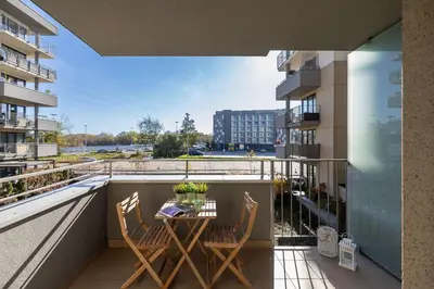 a balcony with a table and chairs on a balcony at Modern Apartment with Parking near Tauron Arena Kraków by Noclegi Renters in Kraków