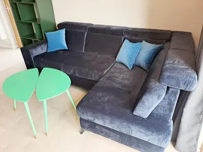 a brown couch with blue pillows and a green table at Leśna24 in Rabka-Zdroj