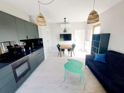a kitchen and living room with a couch and a table at Leśna24 in Rabka-Zdroj