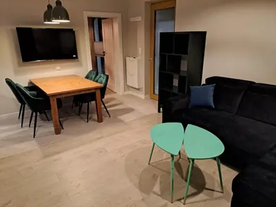 a living room with a couch and a table and chairs at Leśna24 in Rabka-Zdroj