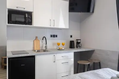 a kitchen with white cabinets and a sink and two glasses at DOLCE VITA Elegant Apartments in Kraków