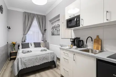 a small kitchen with a bed and a sink at DOLCE VITA Elegant Apartments in Kraków