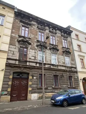 a blue car parked in front of a stone building at DOLCE VITA Elegant Apartments in Kraków