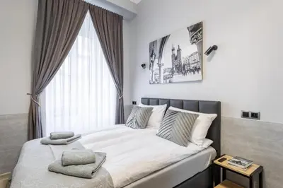 a bed in a bedroom with a large window at DOLCE VITA Elegant Apartments in Kraków