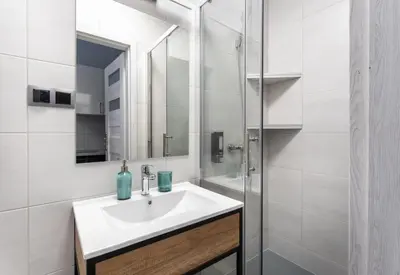a white bathroom with a sink and a mirror at DOLCE VITA Elegant Apartments in Kraków