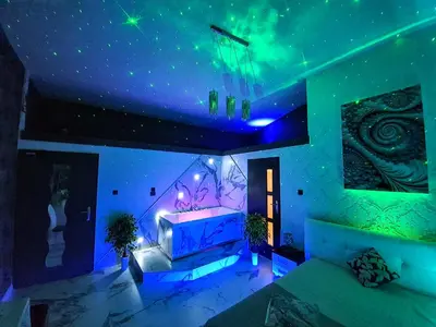 a room with a bed with purple and green lights at Apartament z jacuzzi Kraków Rynek in Kraków