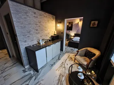a room with a stone wall and a table and chair at Apartament z jacuzzi Kraków Rynek in Kraków