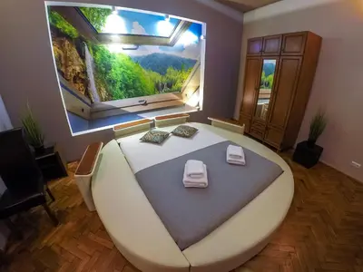 a large bed in a room with a large window at Apartament z jacuzzi Kraków Rynek in Kraków