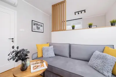 a living room with a gray couch and a table at Apartamenty Warszauera z Klimatyzacją na Krakowskim Kazimierzu by Noclegi Renters in Kraków