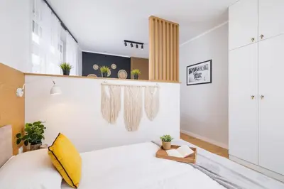 a bedroom with a bed with a yellow pillow at Apartamenty Warszauera z Klimatyzacją na Krakowskim Kazimierzu by Noclegi Renters in Kraków