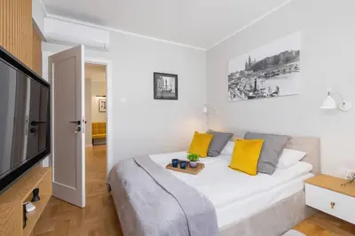 a bedroom with a large white bed with yellow pillows at Apartamenty Warszauera z Klimatyzacją na Krakowskim Kazimierzu by Noclegi Renters in Kraków