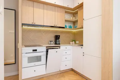 a kitchen with white cabinets and white appliances at Apartamenty Warszauera z Klimatyzacją na Krakowskim Kazimierzu by Noclegi Renters in Kraków