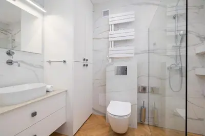 a white bathroom with a toilet and a shower at Apartamenty Warszauera z Klimatyzacją na Krakowskim Kazimierzu by Noclegi Renters in Kraków