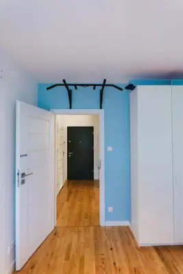 an empty room with a hallway with blue walls and wood floors at Stylowy Apartament Eden-Arena in Kraków