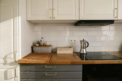 a kitchen with white cabinets and a counter top at Stylowy Apartament Eden-Arena in Kraków