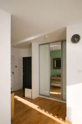an empty room with a clock on a wall at Stylowy Apartament Eden-Arena in Kraków