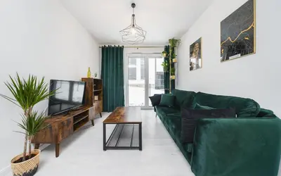 a living room with a green couch and a television at Wielicka in Kraków