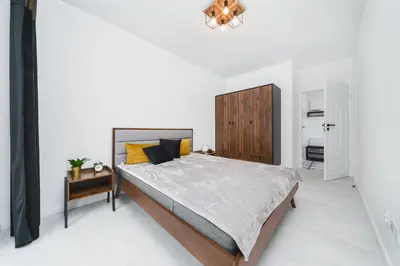 a bedroom with a large bed with a wooden cabinet at Wielicka in Kraków