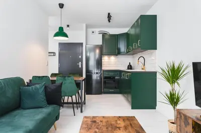 a kitchen with green cabinets and a green couch at Wielicka in Kraków