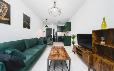 a living room with a green couch and a table at Wielicka in Kraków