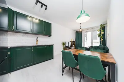 a kitchen with green cabinets and a wooden table at Wielicka in Kraków